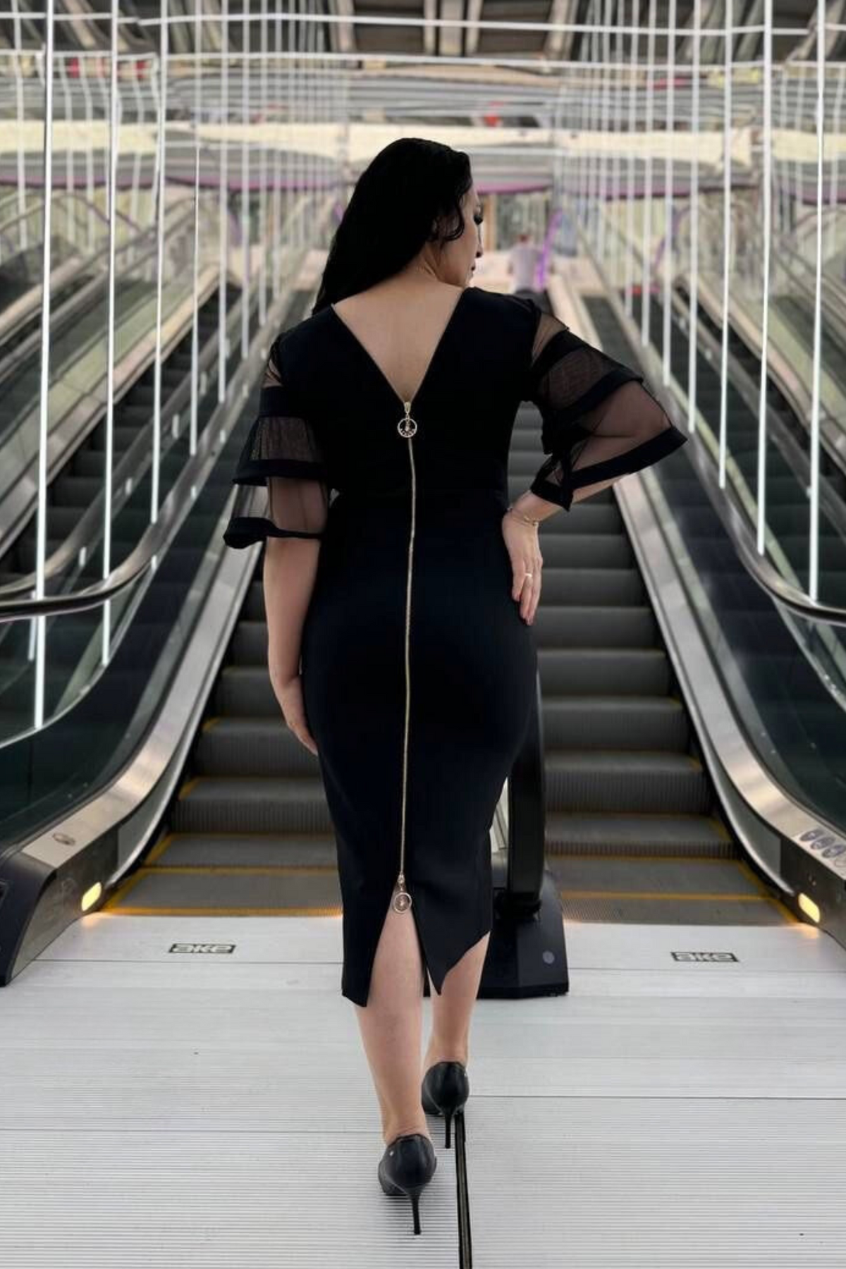 Abito midi nero per donne curvy con maniche a campana in tulle e zip doppio cursore, stile elegante e moderno.