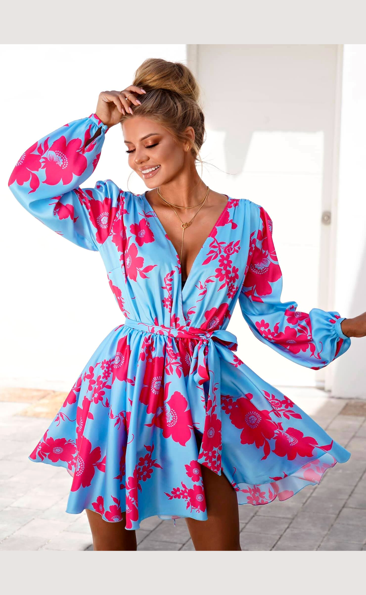 Abito estivo azzurro floreale Moda-Mania con maniche lunghe e gonna a ruota allacciabile in vita, ideale per la stagione calda.