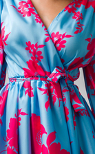 Abito estivo azzurro floreale Moda-Mania con maniche lunghe e gonna a ruota allacciabile in vita, perfetto per la stagione calda.