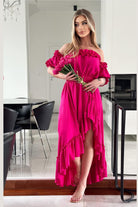 Abito estivo fucsia Moda-Mania, corto davanti e lungo dietro, con scollo a barchetta, maniche rimuovibili e cintura.