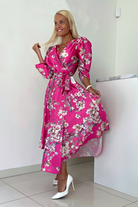 Abito midi fucsia svasato con fantasia floreale, maniche a sbuffo e allacciatura in vita, marca Moda-Mania.