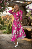 Abito midi fucsia svasato con fantasia floreale, maniche a sbuffo e cintura allacciabile in vita, marca Moda-Mania.