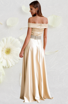Abito lungo beige Artista con scollatura a barchetta, cintura con strass rimovibile, tessuto elegante e dettagli raffinati.