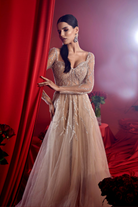 Abito lungo nude beige da cerimonia Moda-Mania, svasato con maniche lunghe, corpetto a cuore e decorazioni in paillettes.