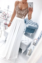 Abito lungo svasato bianco con spacco laterale e corpetto in tulle ricamato dorato, di Moda-Mania, indossato su modella.