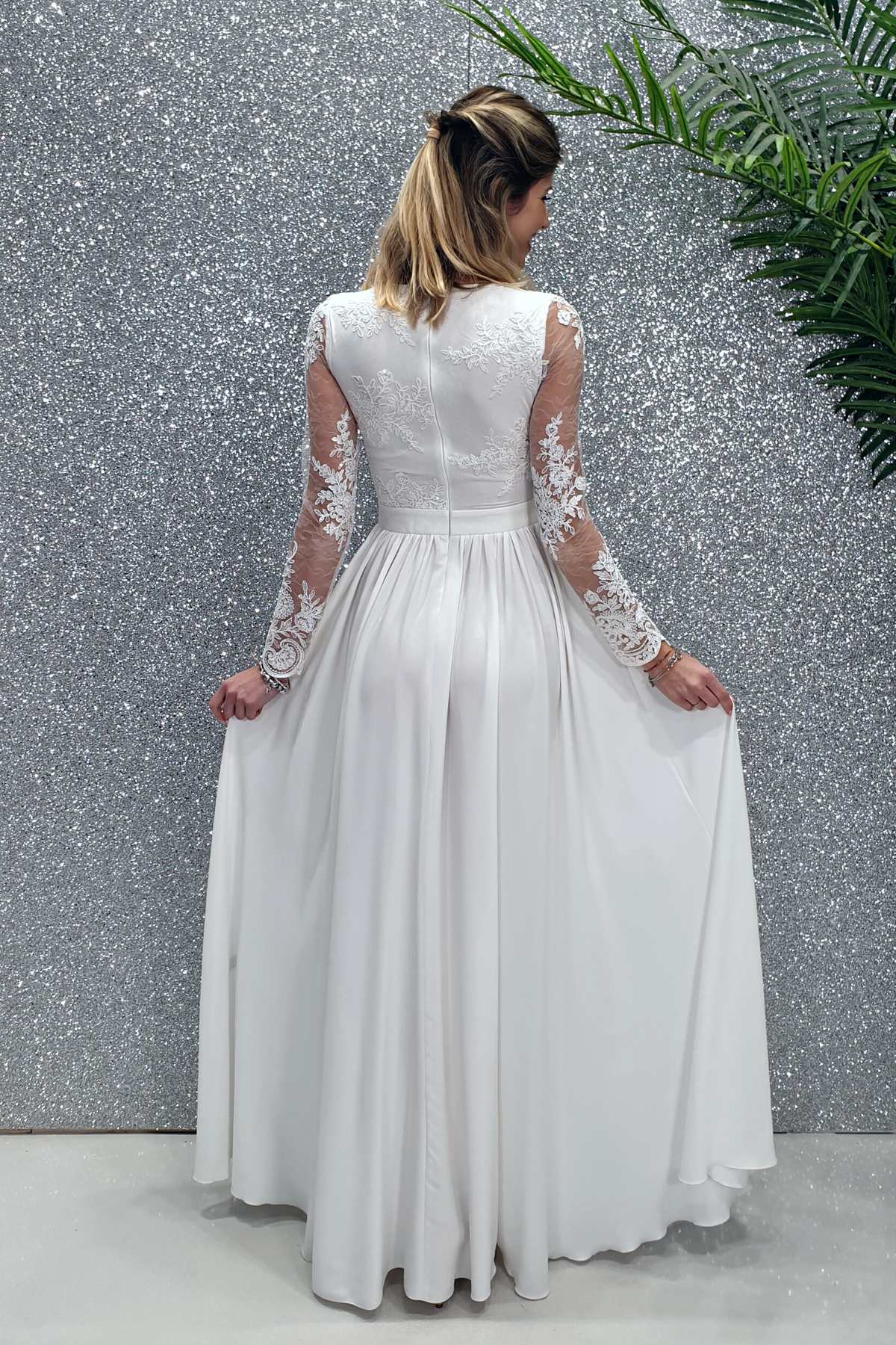 Abito lungo svasato bianco con spacco laterale e corpetto in tulle ricamato, moda-mania, elegante e femminile.