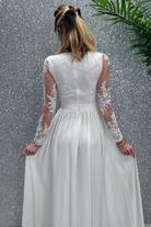 Abito lungo svasato bianco Moda-Mania con spacco laterale e corpetto in tulle ricamato, elegante e femminile.