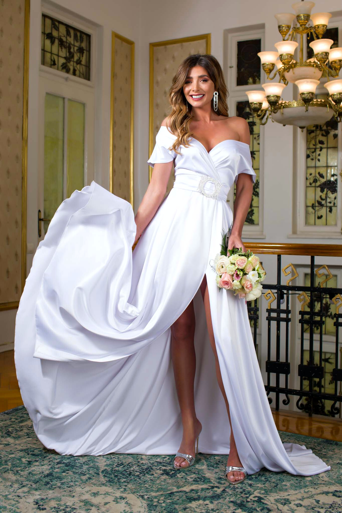 Abito lungo svasato bianco Pretty Girl con spacco laterale e fibbia gioiello, vestito elegante in tessuto leggero.