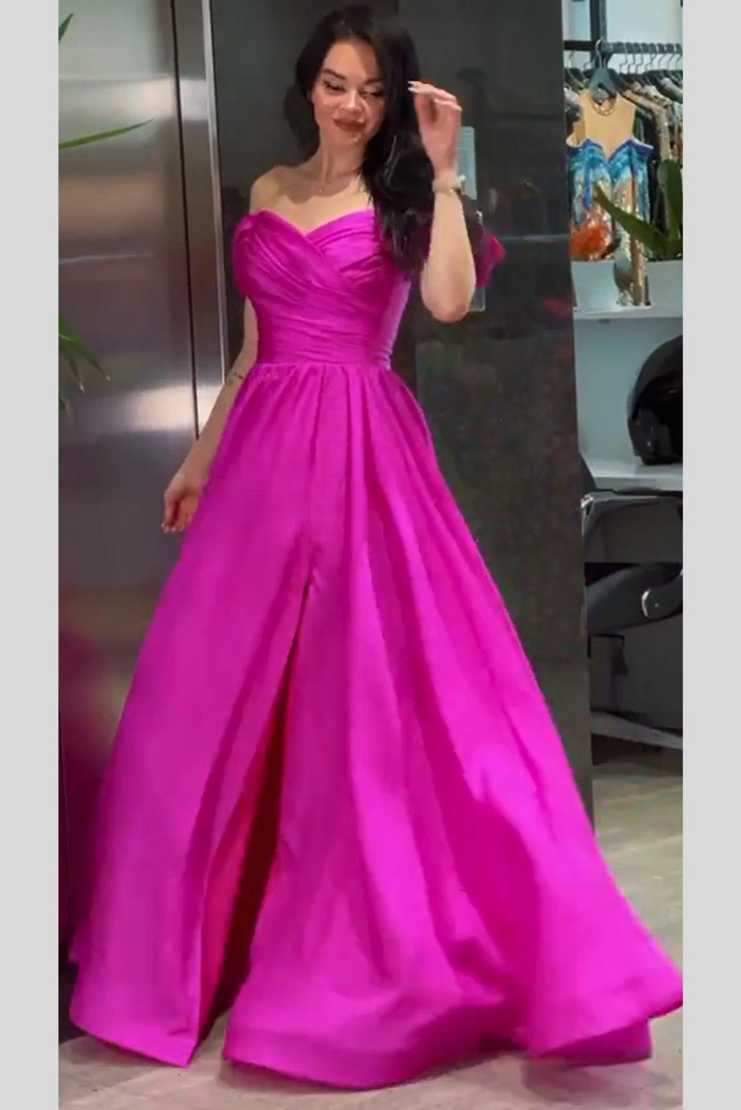 Abito lungo svasato da cerimonia fucsia Moda-Mania con scollo a barchetta e stringhe regolabili, dettaglio dell'abito elegante.