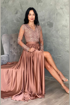 Abito lungo svasato dorato bronzo Moda-Mania con tessuto lucido, spacco laterale e corpetto in tulle ricamato.