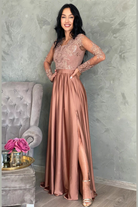 Abito lungo svasato dorato bronzo in tessuto lucido con spacco laterale e corpetto in tulle ricamato, firmato Moda-Mania.