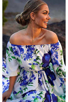 Abito lungo svasato estivo bianco con fantasia floreale blu, scollo a barchetta, tessuto satinato, brand Moda-Mania.