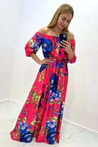 Abito lungo svasato estivo fucsia con fantasia floreale blu, scollo a barchetta in tessuto satinato, Moda-Mania.