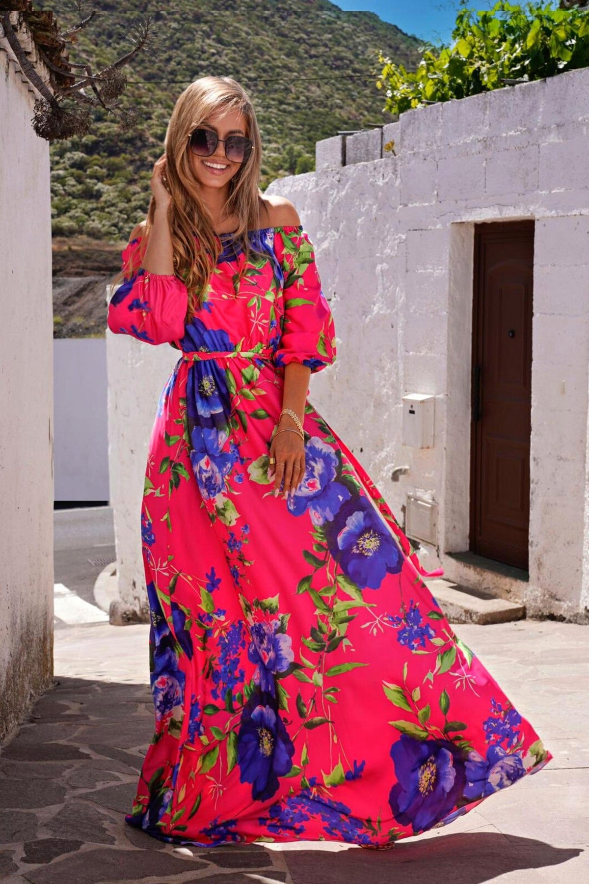 Abito lungo svasato estivo fucsia con fantasia floreale blu, scollo a barchetta in tessuto satinato, moda-mania.
