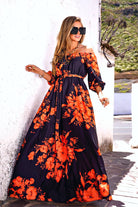 Abito lungo svasato estivo nero e bianco con fantasia floreale arancione e fucsia, scollo a barchetta in tessuto satinato.