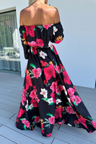 Abito lungo svasato estivo nero e bianco con fantasia floreale fucsia, scollo a barchetta, tessuto satinato, moda-mania