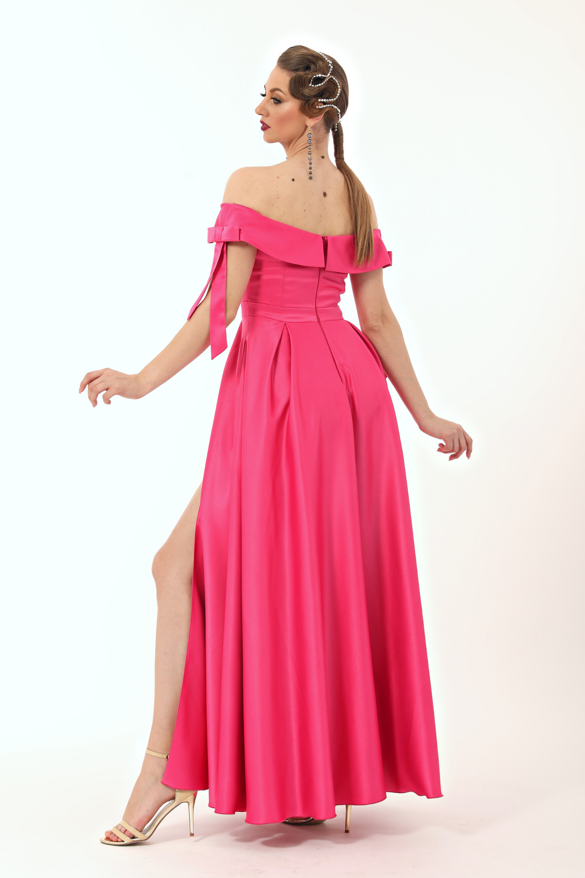 Abito lungo svasato fucsia in taffetà con scollo a barchetta, spacco laterale e fiocchi decorativi, firmato Moda-Mania.