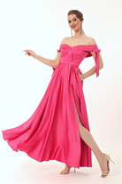 Abito lungo svasato fucsia in taffetà Moda-Mania con scollo a barchetta, spacco laterale e fiocchi decorativi.
