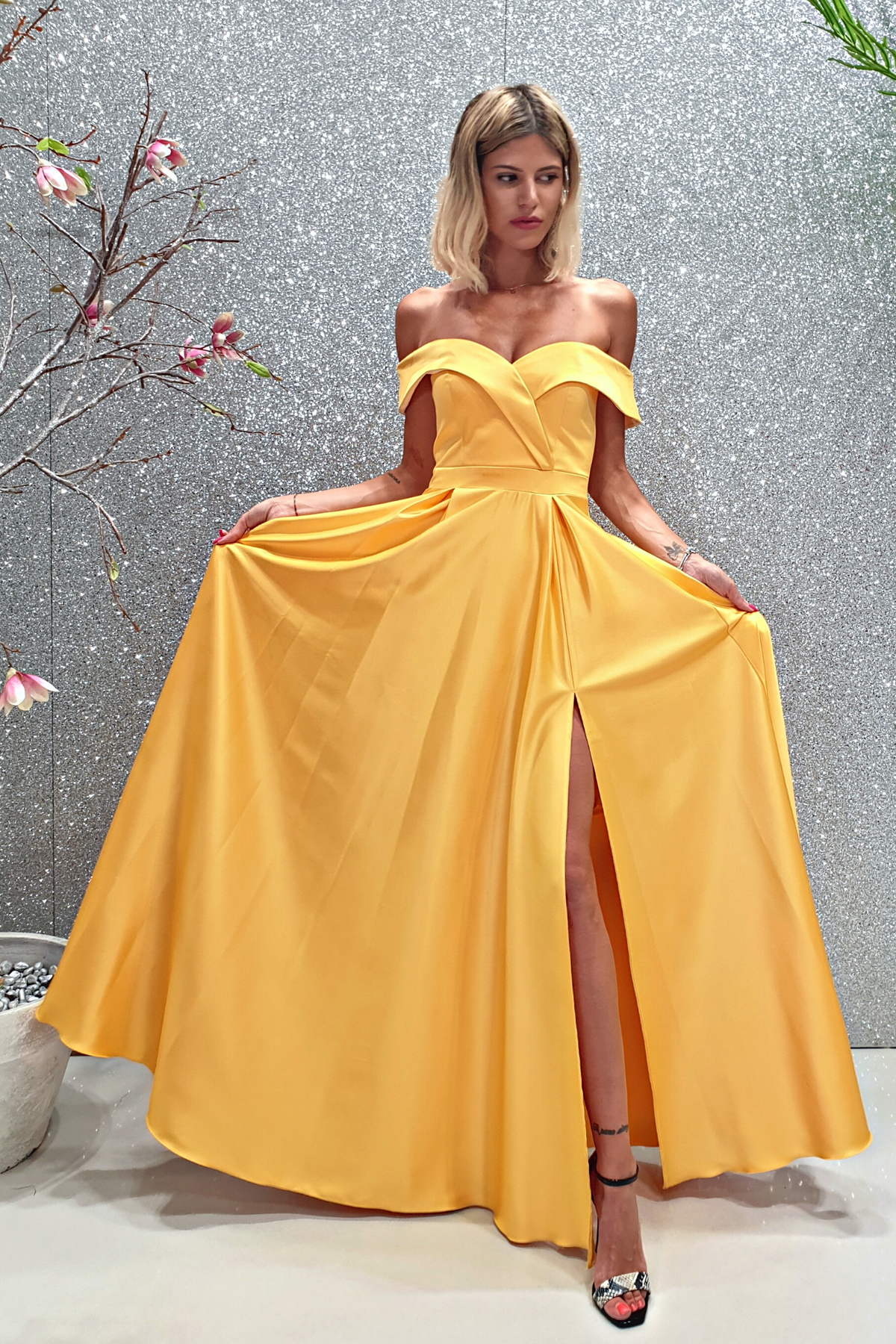 Abito lungo svasato giallo in taffetà Moda-Mania con scollo a barchetta e spacco laterale, elegante e femminile.