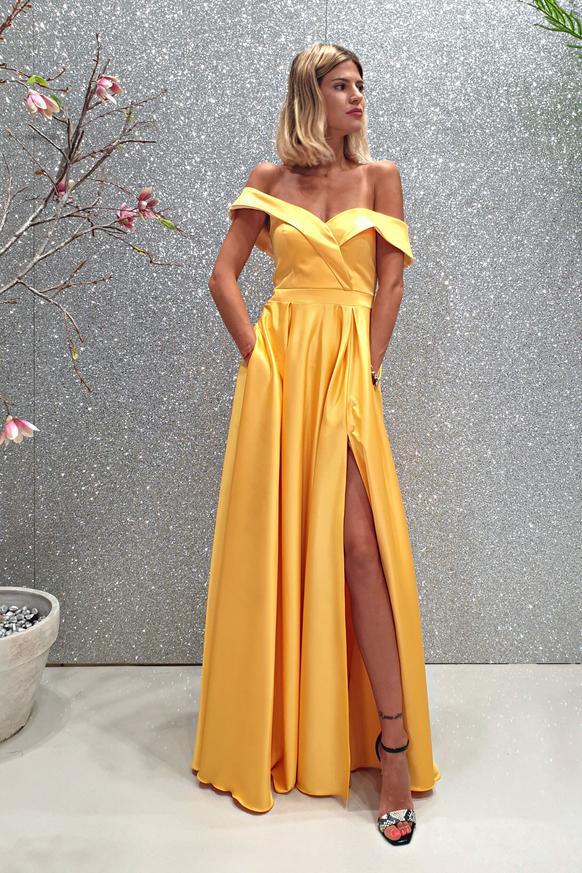 Abito lungo svasato giallo in taffetà Moda-Mania con scollo a barchetta e spacco laterale, vista frontale.