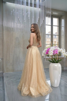 Abito lungo svasato giallo oro Moda-Mania con corpetto in tulle a rette e gonna in tulle glitterato dorato.