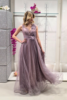 Abito lungo svasato lilla in tulle glitterato con spacco e dettagli di fiori decorativi, Moda-Mania, moda elegante femminile.