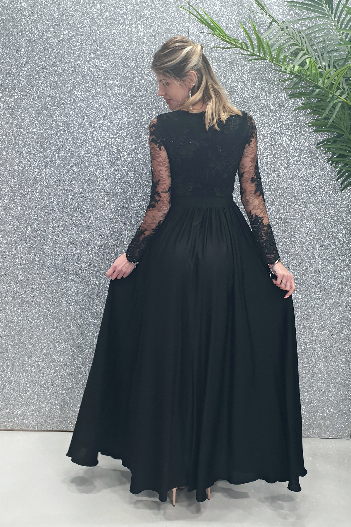 Abito lungo nero svasato con spacco laterale e corpetto in tulle ricamato, da Moda-Mania, in dettaglio.