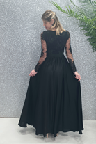 Abito lungo nero svasato con spacco laterale e corpetto in tulle ricamato, da Moda-Mania, in dettaglio.