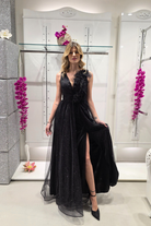 Abito lungo svasato nero in tulle glitterato con spacco e dettagli floreali, firmato Moda-Mania, indossato in primo piano.
