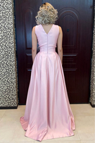 Abito lungo svasato rosa Moda-Mania con corpetto in perline, piume decorative e spacco laterale, perfetto per occasioni eleganti.