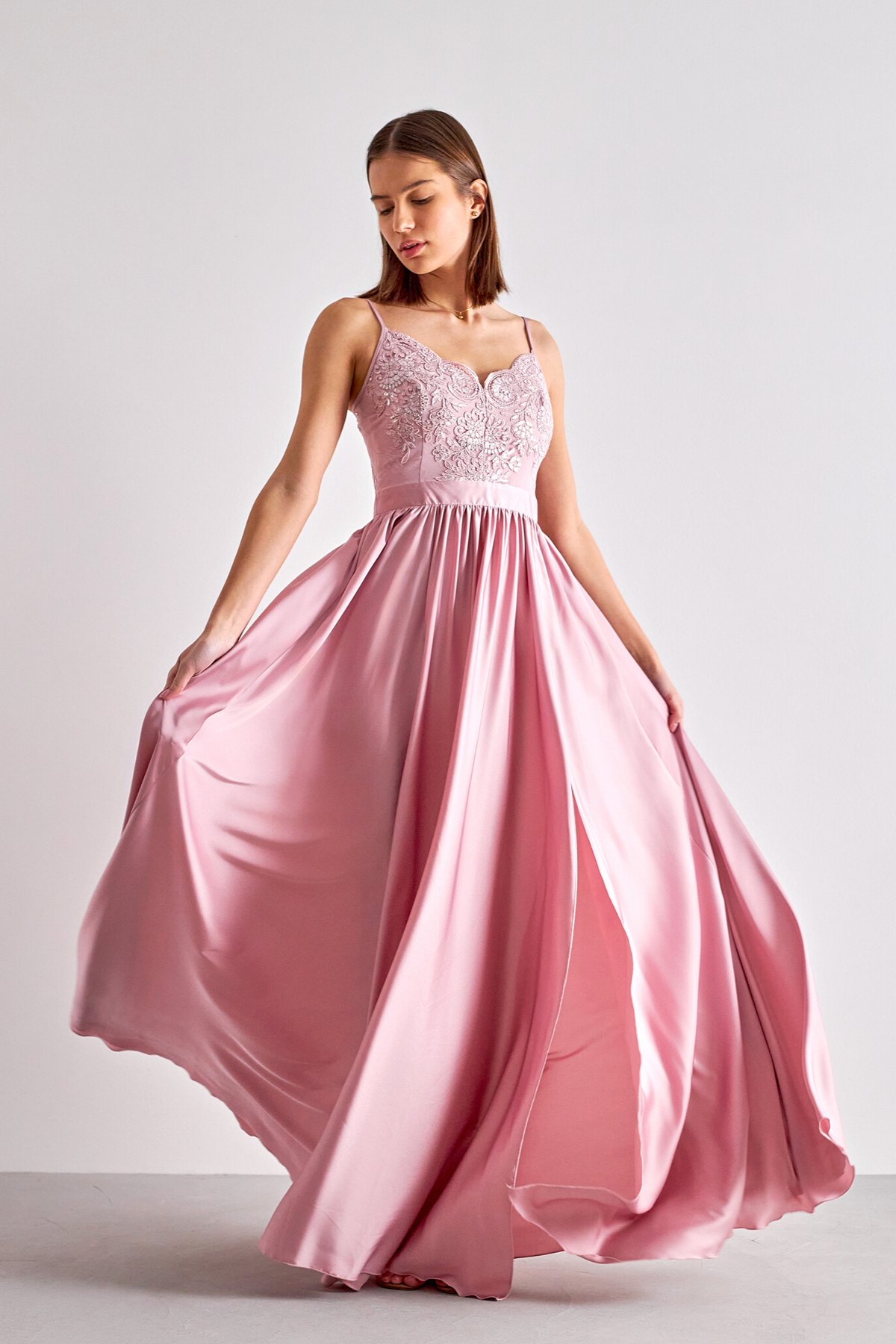 Abito lungo svasato rosa chiaro Moda-Mania con spacco laterale e corpetto in tulle ricamato, dettagli eleganti e femminili.