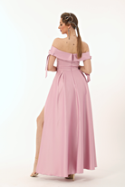 Abito lungo svasato rosa in taffetà Moda-Mania con scollo a barchetta, spacco laterale e fiocchi decorativi.