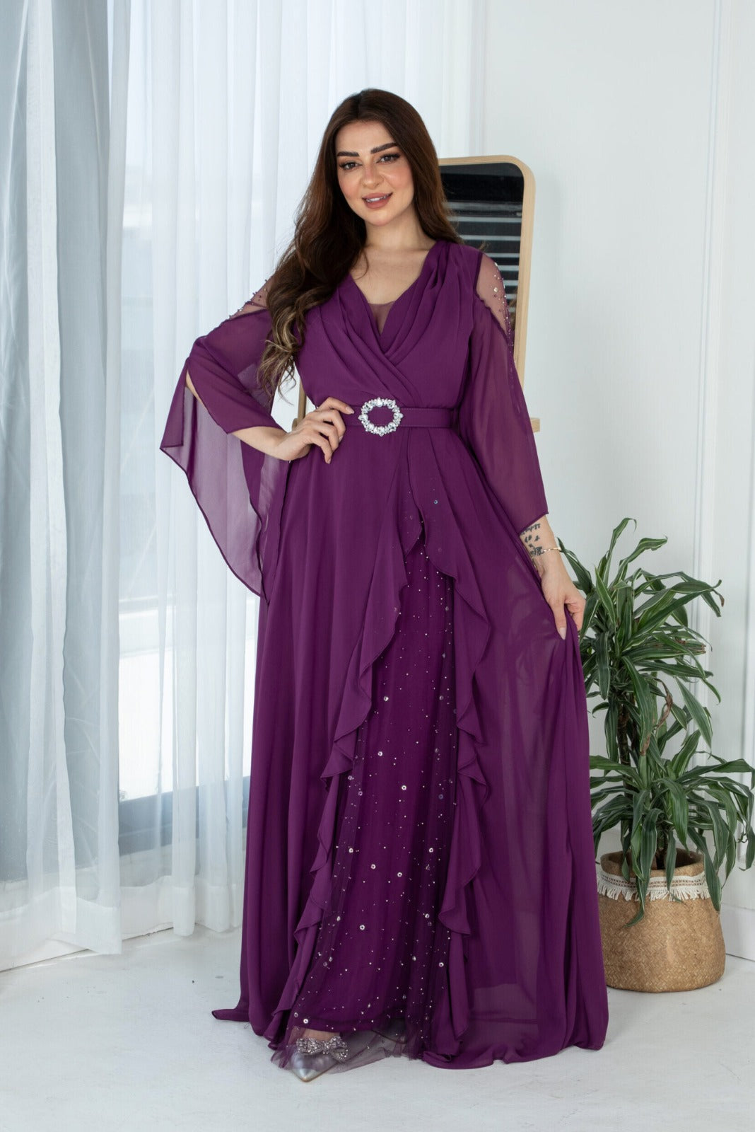 Abito lungo svasato viola in georgette con maniche lunghe e cinturino, firma Moda-Mania, vestibilità elegante e femminile.