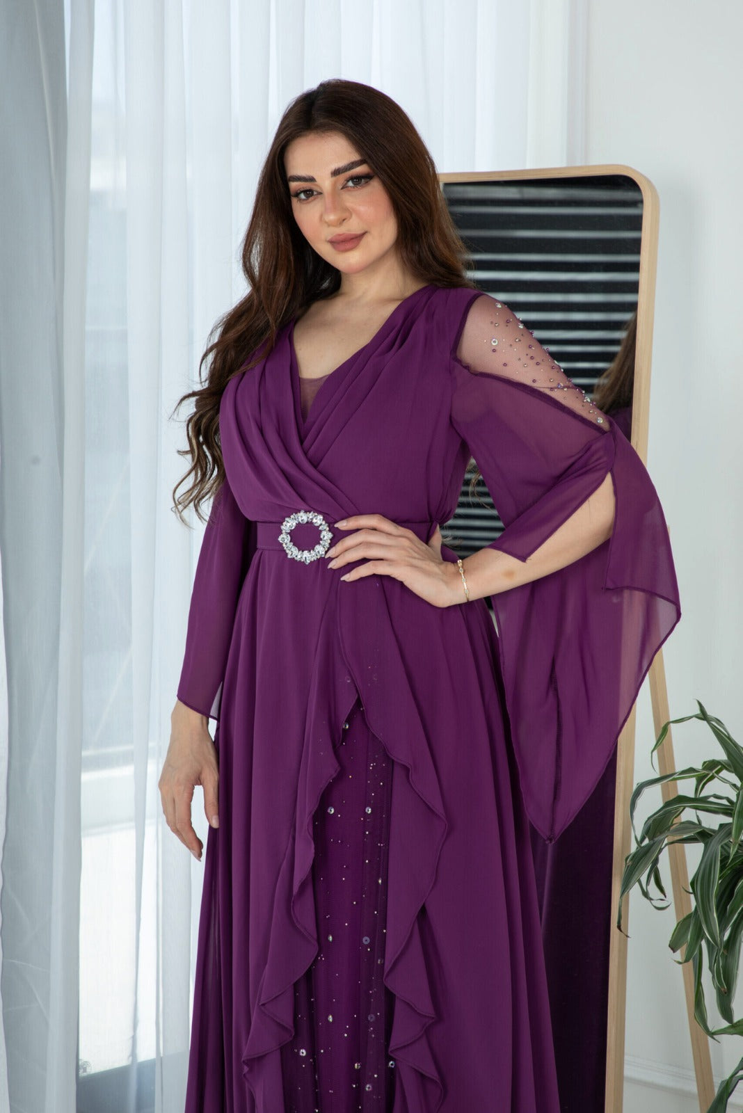 Abito lungo svasato viola in georgette di Moda-Mania con maniche lunghe e cinturino, dettagli eleganti e tessuto leggero.