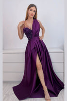 Abito lungo svasato viola prugna Axa con spacco laterale, corpetto in perline, piume e fiori 3D, moda elegante e raffinata.