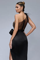 Abito midi nero Bby con corpetto monospalla in tulle, fiori in tessuto, gonna in taffetà con spacco, accessoriato e elegante.