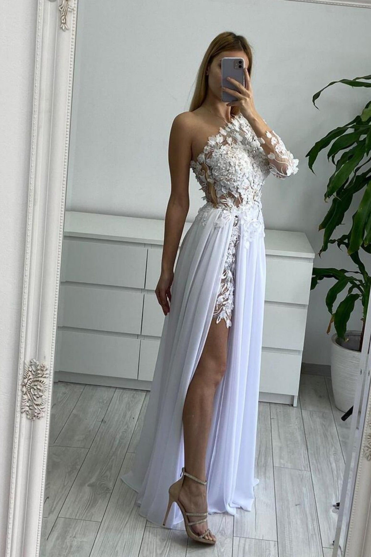 Abito lungo bianco con manica singola, strascico in georgette e corpetto a fiori 3D di Moda-Mania.