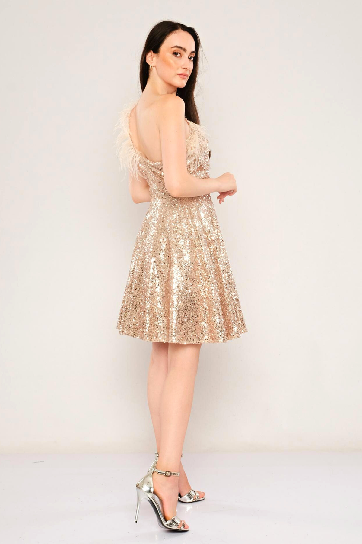 Abito princess dorato in paillettes mono spalla di Moda-Mania con piume, abito corto elegante e accessoriato.