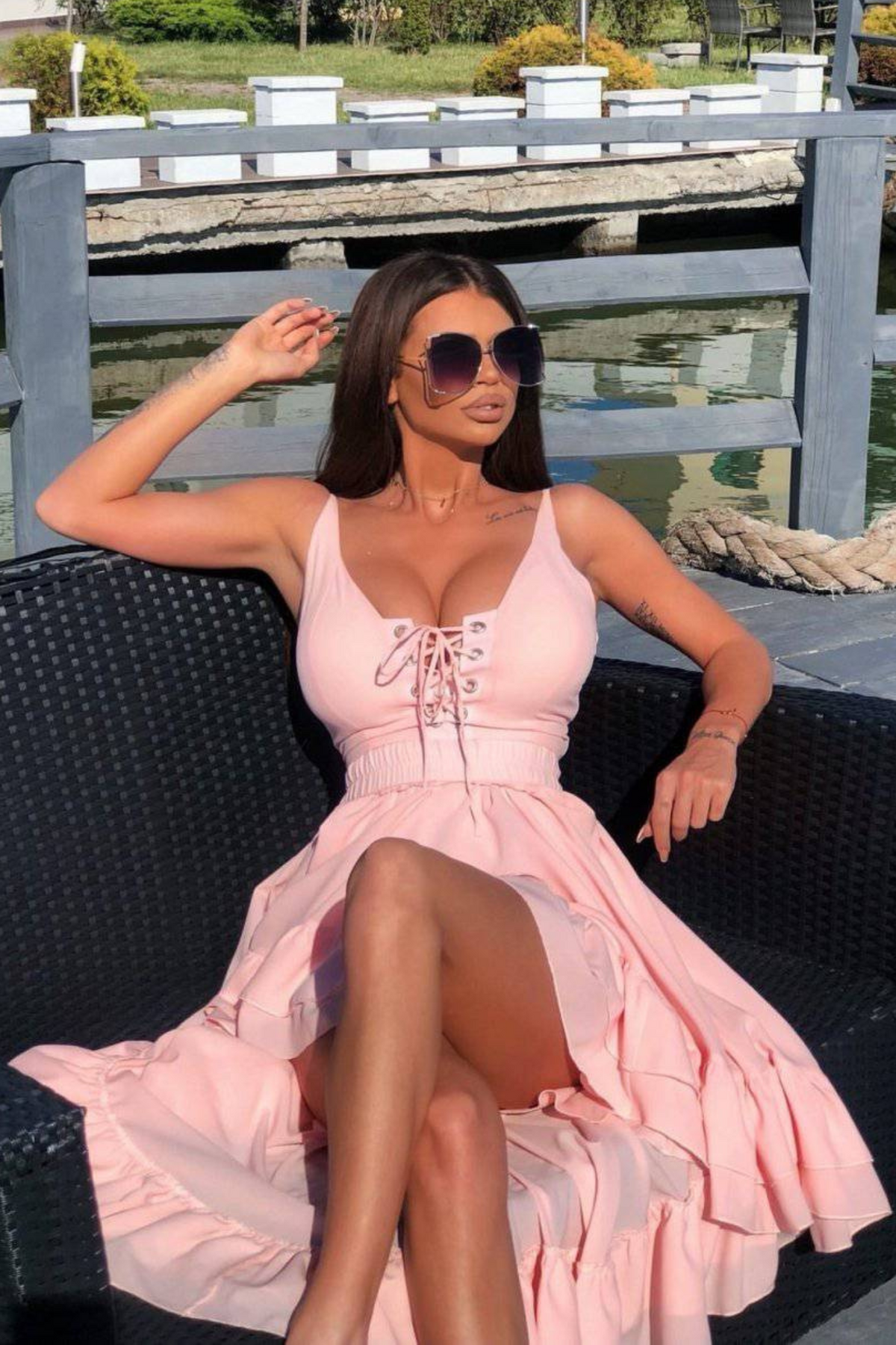 Abito rosa Foggi con coda, volant e stringhe decorative, vestito elegante donna con dettagli raffinati e tessuto leggero.