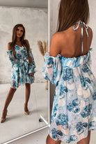 Abito svasato bianco con fantasia floreale celeste, maniche lunghe e spalle scoperte, modello Moda-Mania, abiti corti elegante