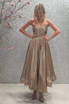 Abito lungo svasato in tessuto glitterato dorato bronzo con corpetto cuore a punta e lunghezza asimmetrica, di Moda-Mania.