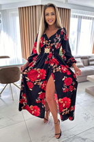 Abito lungo svasato nero con stampa floreale rossa, spacco e cintura elasticizzata, brand Moda-Mania.