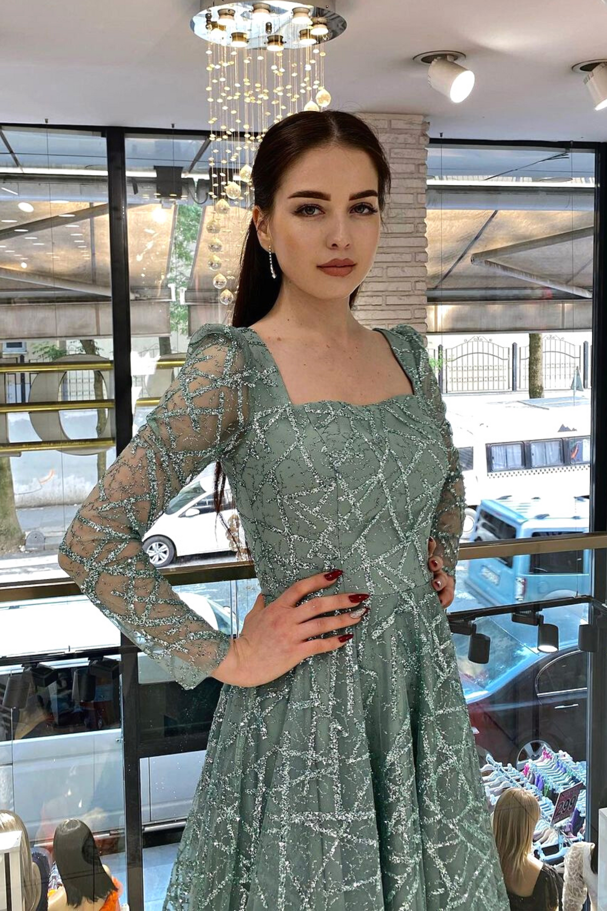 Abito svasato midi verde menta in tulle con trama glitterata e maniche lunghe, firmato Moda-Mania, visibile in dettaglio.