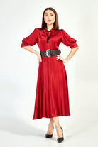 Abito midi svasato rosso con piccoli pois neri, cintura nera, di Moda-Mania, vista frontale su sfondo neutro.