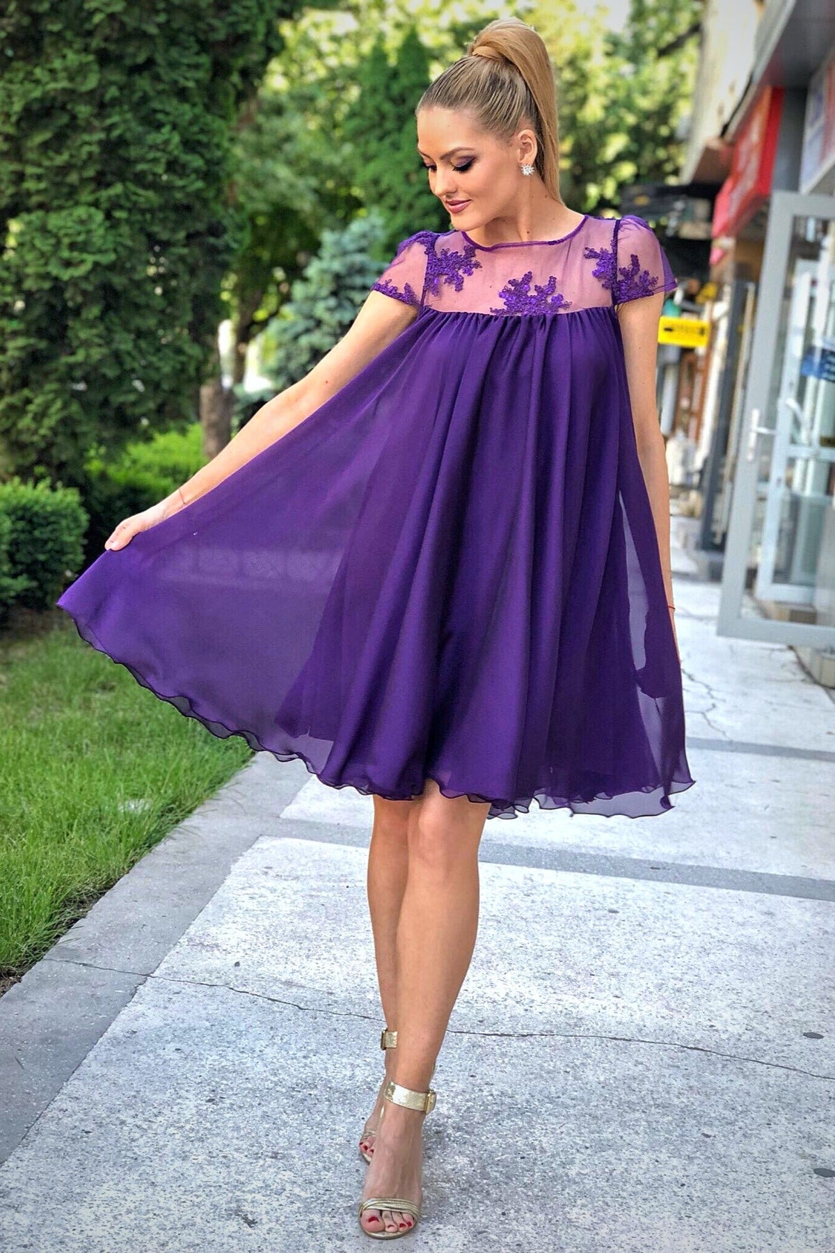 Abito svasato viola Artista in tessuto georgette con décolleté in tulle floreale, corto e elegante, dettaglio floreale sul busto.