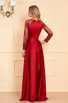 Abito lungo elegante rosso Artista in taffetà con maniche in tulle floreale e spacco laterale, visibile in dettaglio.