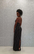Abito lungo nero Bby con scollatura profonda, schiena scoperta e dettagli incrociati, in tessuto elegante e di moda.