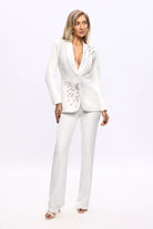 Completo tailleur bianco Bby con giacca a V con piume applicazioni argento e pantaloni a gamba larga, elegante e raffinato.