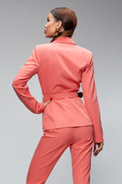 Completo tailleur elegante salmone Bby a due pezzi con giacca, pantaloni, cintura e fibbia dorata, stile sofisticato e femminile.