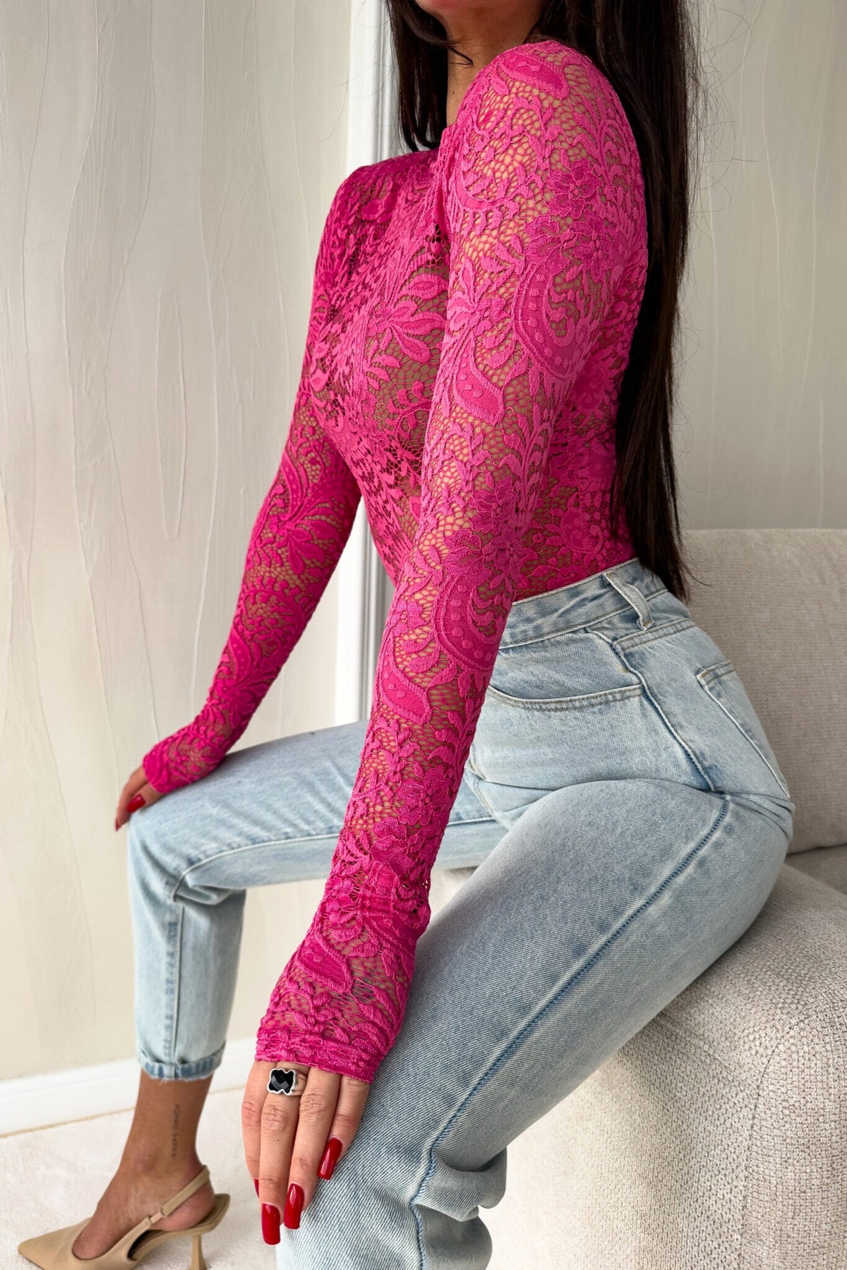 Blusa aderente fucsia a maniche lunghe in pizzo elasticizzato con fantasia floreale, moda-mania, elegante e femminile.